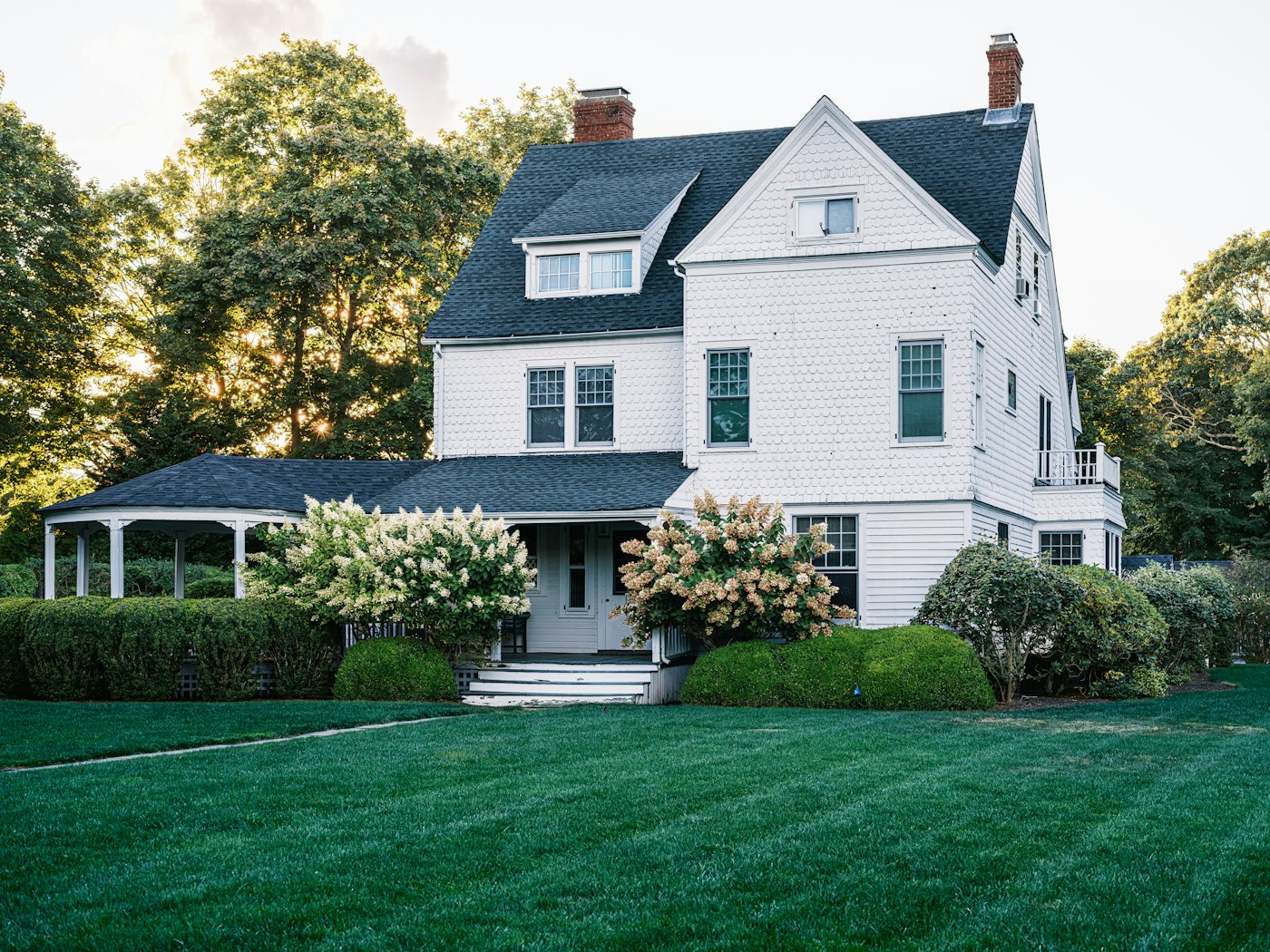 Bright white two-story home with clean siding and a healthy lawn after a soft wash